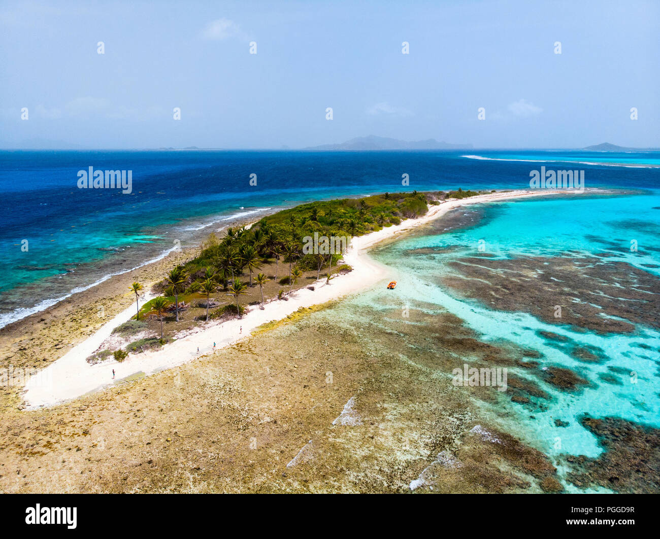 Antena drone vista de Petit Tabac isla tropical, aguas turquesas del mar Caribe de Tobago Cays, y una familia con niños en San Vicente y las Granadinas Foto de stock