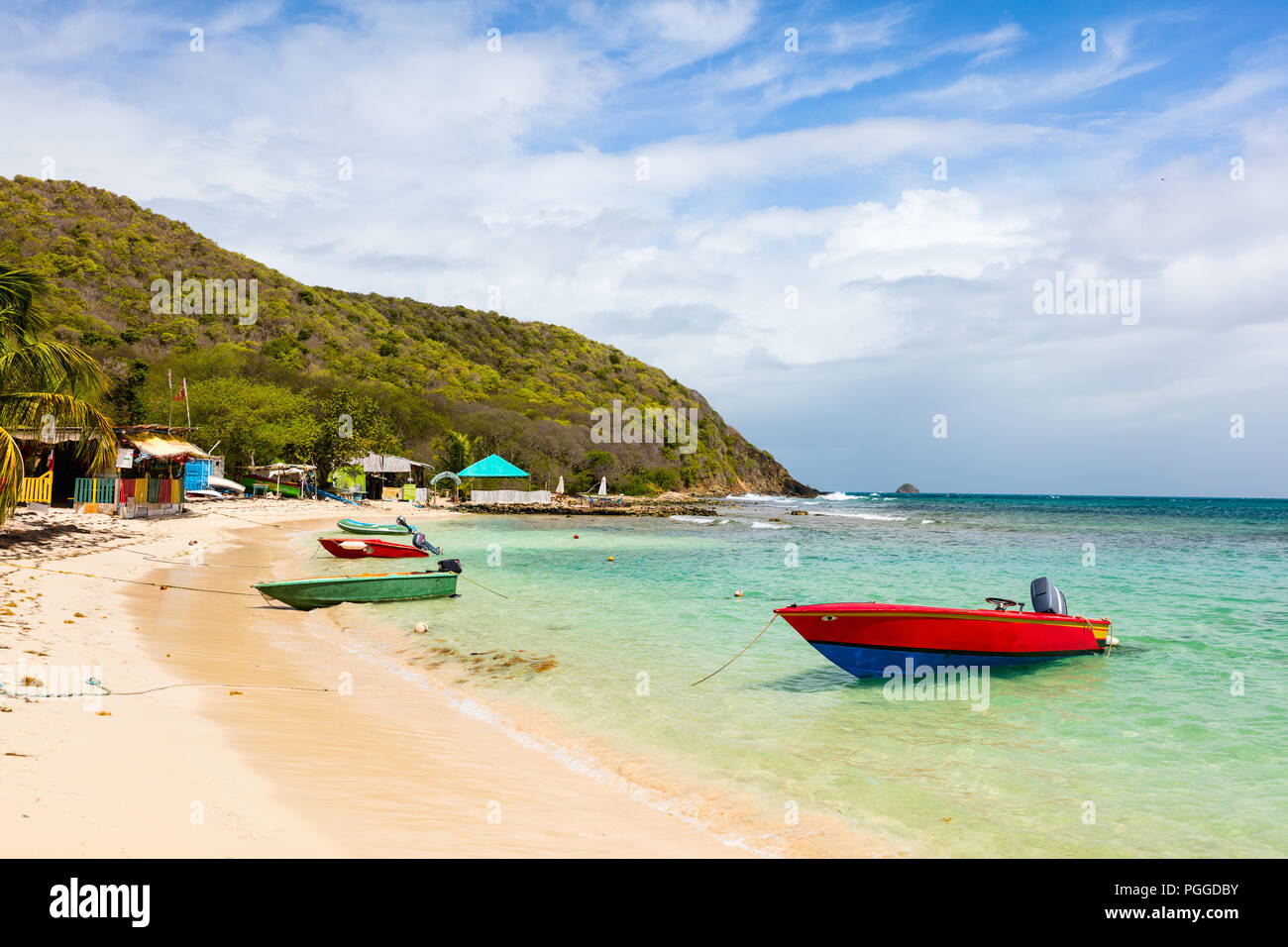 Tropical idílica playa de arena blanca, palmeras y aguas turquesas del Mar Caribe en la isla de Mayreau agua en San Vicente y las Granadinas Foto de stock