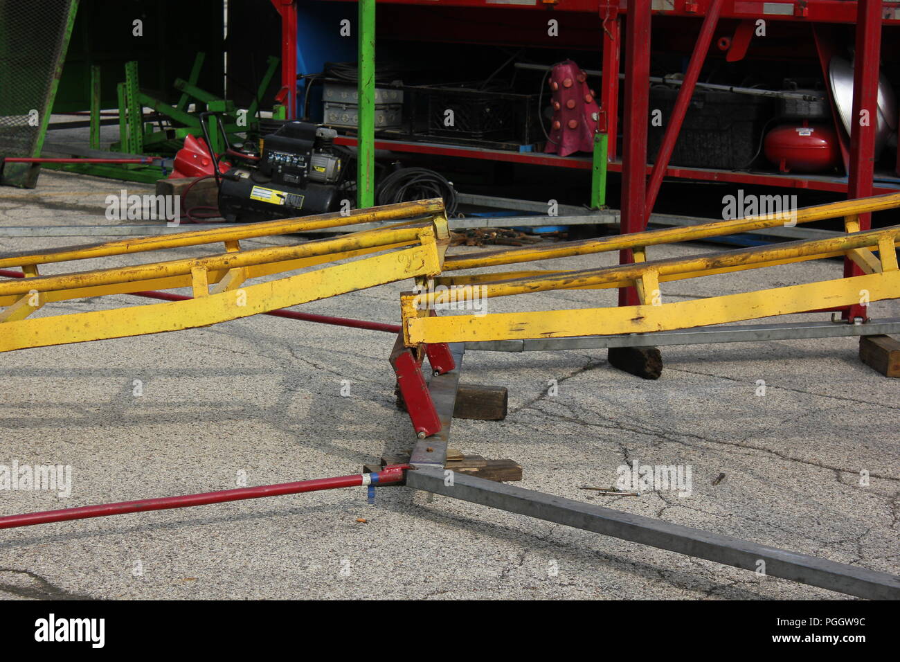 Desconectado o roto de la vía del tren para un viaje de carnaval kiddie ride roller coaster en construcción en un centro comercial de plaza de aparcamiento en Niles, Illinois, EE.UU. en una soleada mañana de verano. Foto de stock