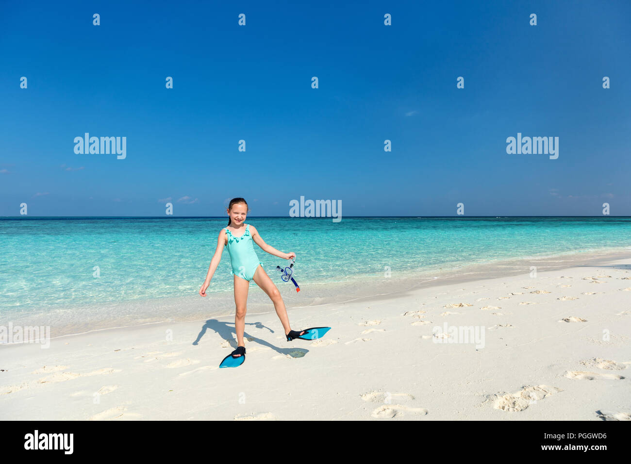 Adorable niña con equipo de buceo en la playa durante las vacaciones de verano Foto de stock