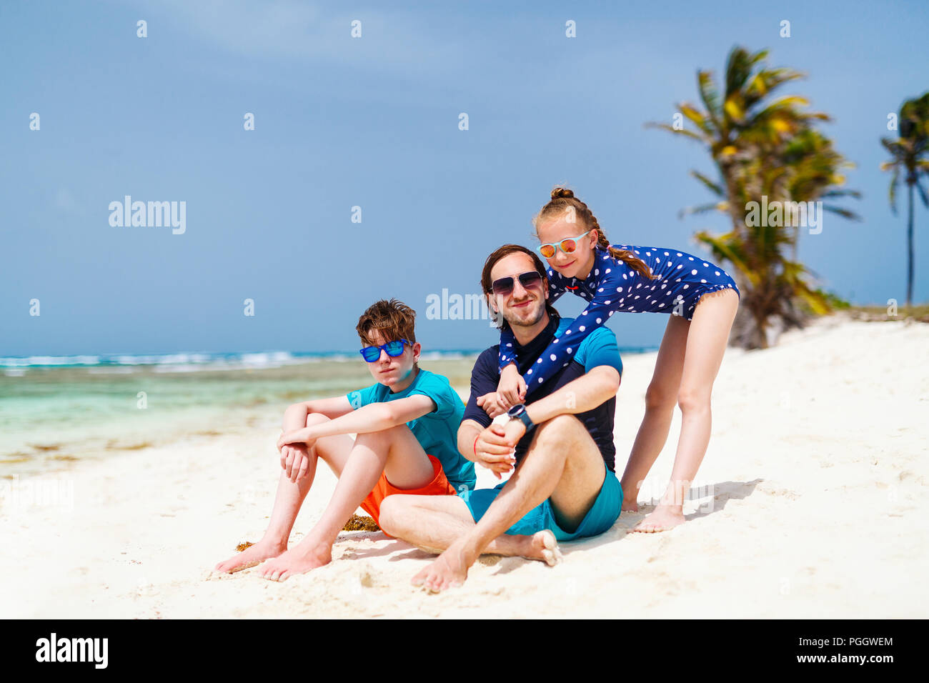 Padre e hijos disfrutar de vacaciones en la playa en isla tropical Foto de stock