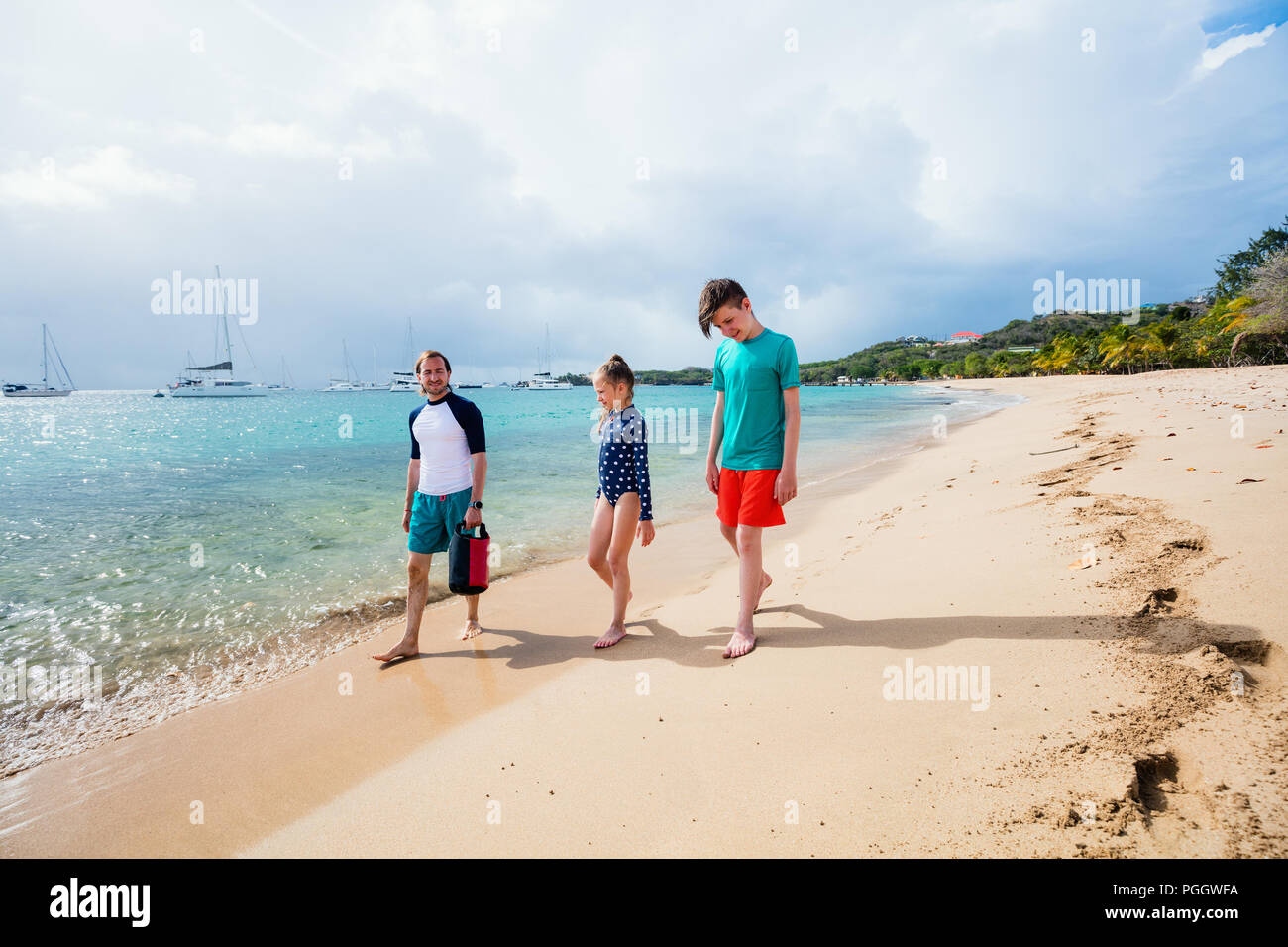 Padre e hijos disfrutar de vacaciones en la playa en isla tropical Foto de stock