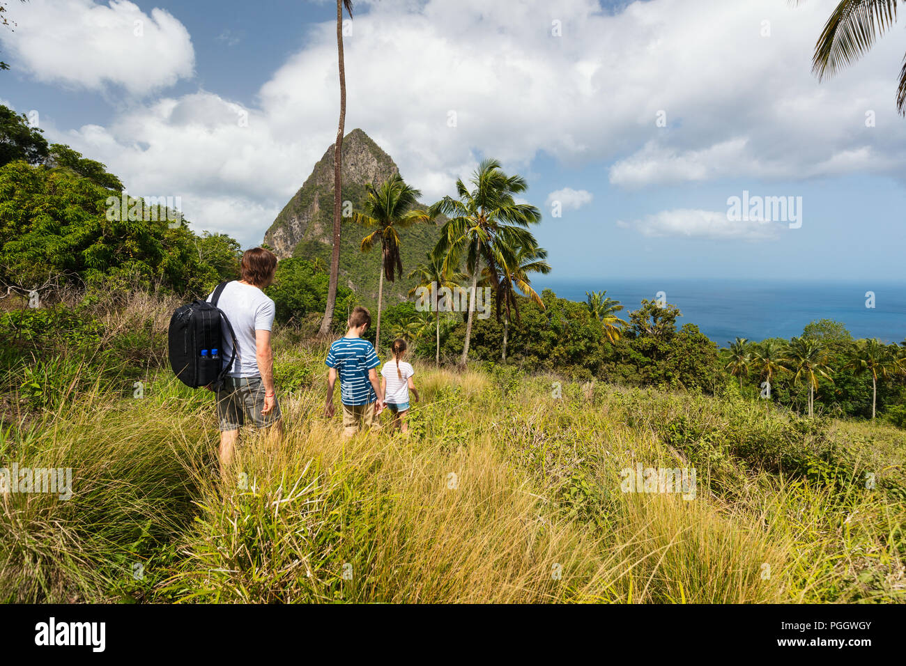 Familia de padre e hijos el senderismo en verano en la isla tropical de Santa Lucía en el Caribe con impresionantes vistas a la montaña de Pitons icónico Foto de stock