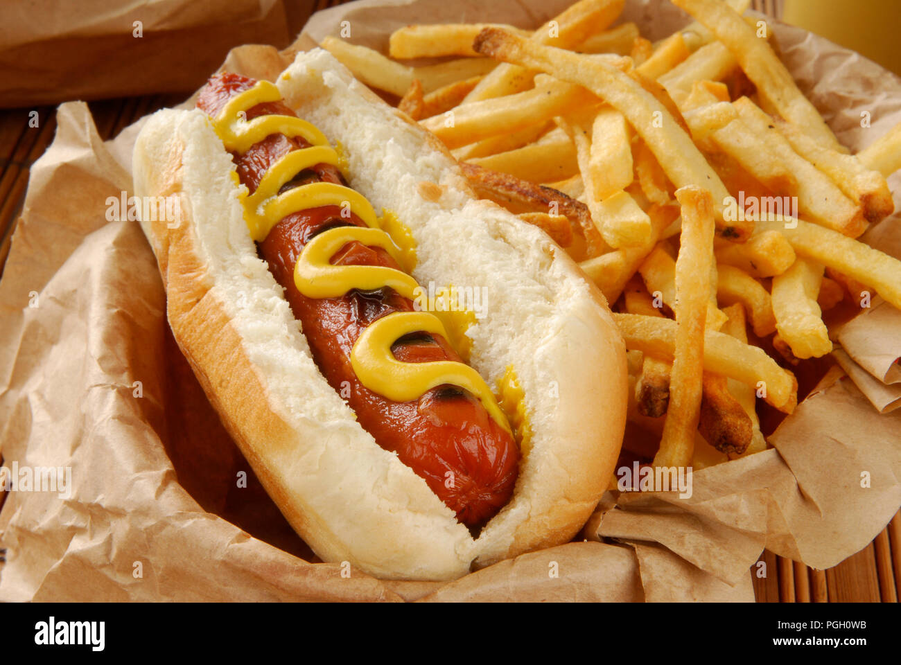 Un hot dog con papas fritas closeup servidos en una cesta Fotografía de
