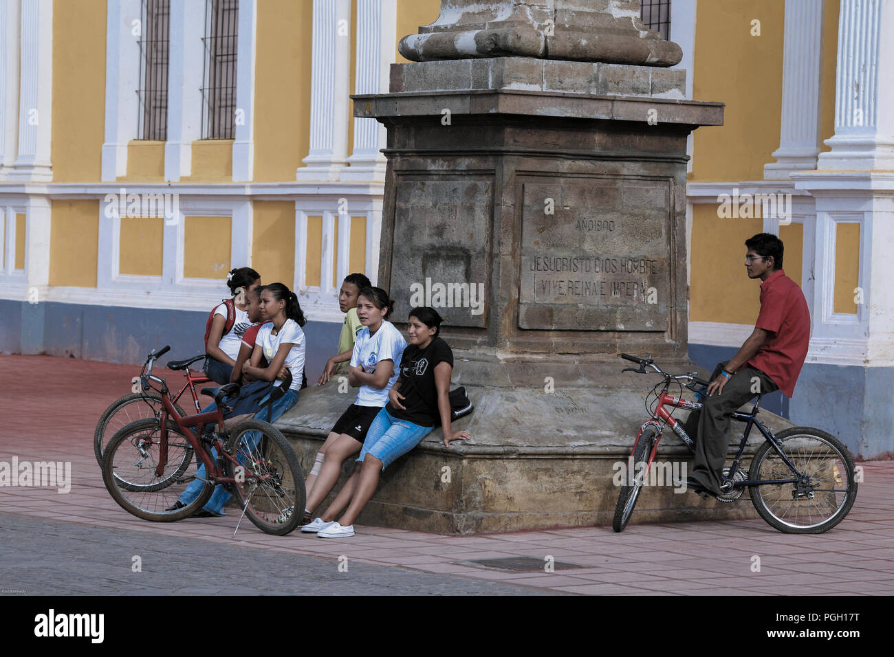 Grupo de jóvenes sentados en monumento a las afueras de la Catedral de Granada en Granada, Nicaragua Foto de stock
