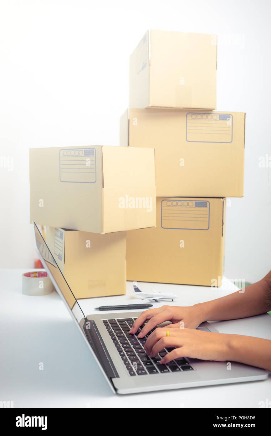Inicie empresaria o mujer freelance concepto , tecleando ordenador con caja, marketing online caja de embalaje y entrega Foto de stock