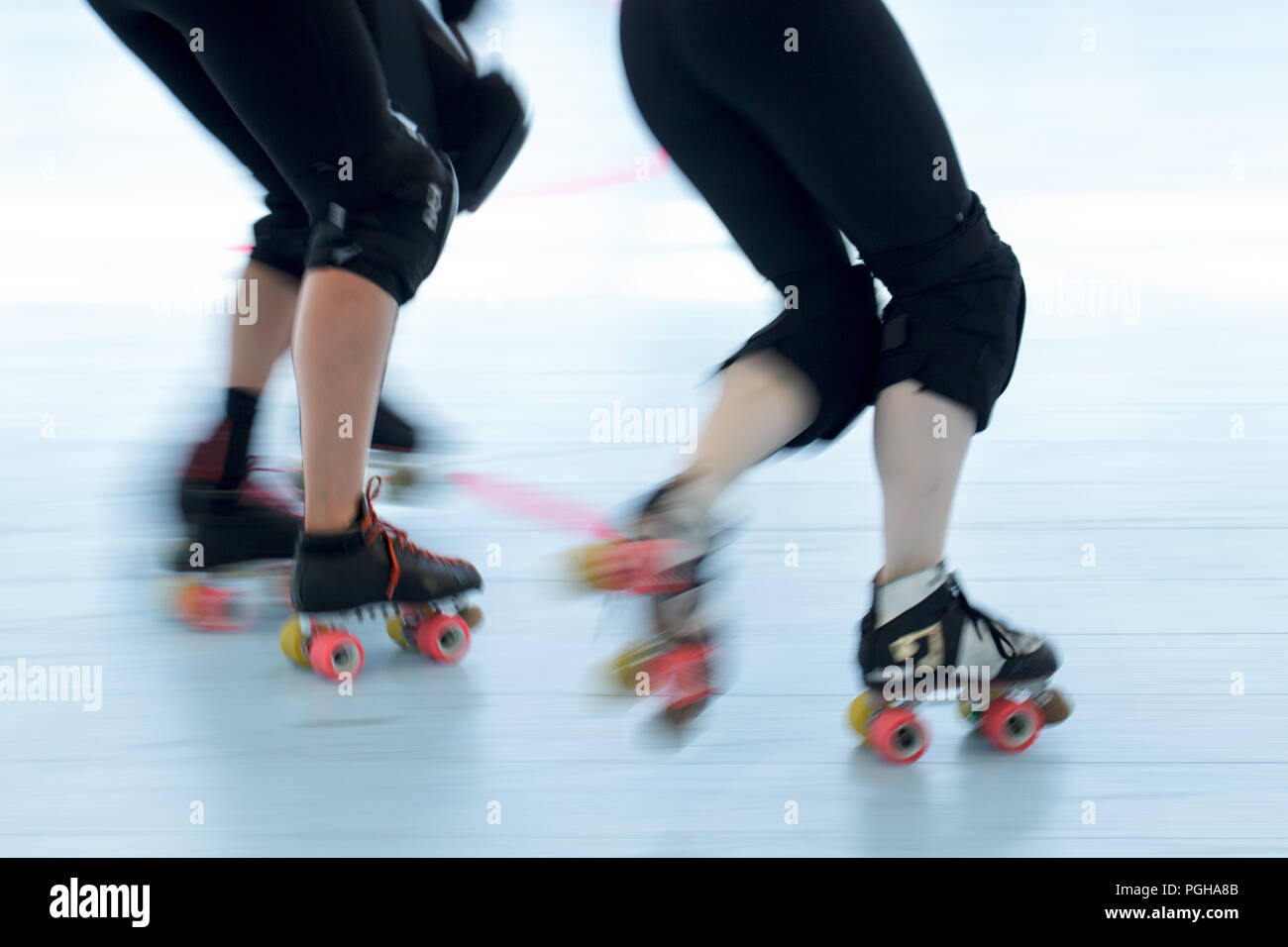 Roller derby patinadores de cerca. Acción paneo de desenfoque de movimiento de las piernas y los pies. Foto de stock