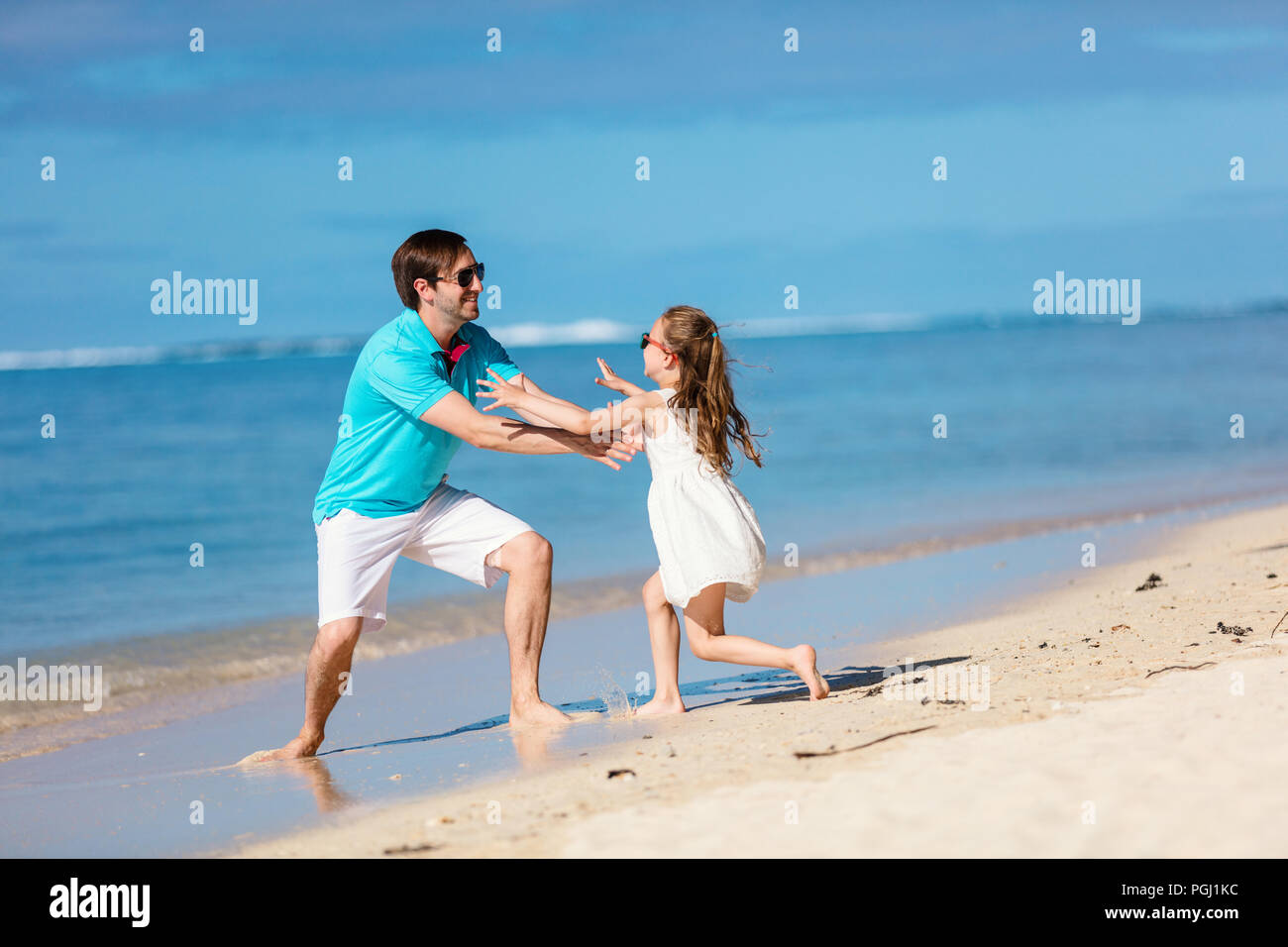 Feliz padre y su adorable hija pequeña en el Tropical Beach durante las vacaciones de verano Foto de stock