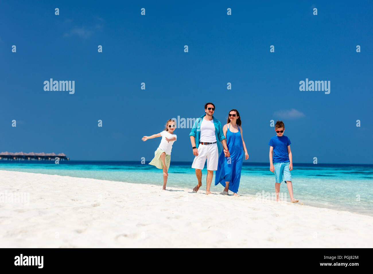 Hermosa familia feliz en unas vacaciones tropicales en la playa Foto de stock