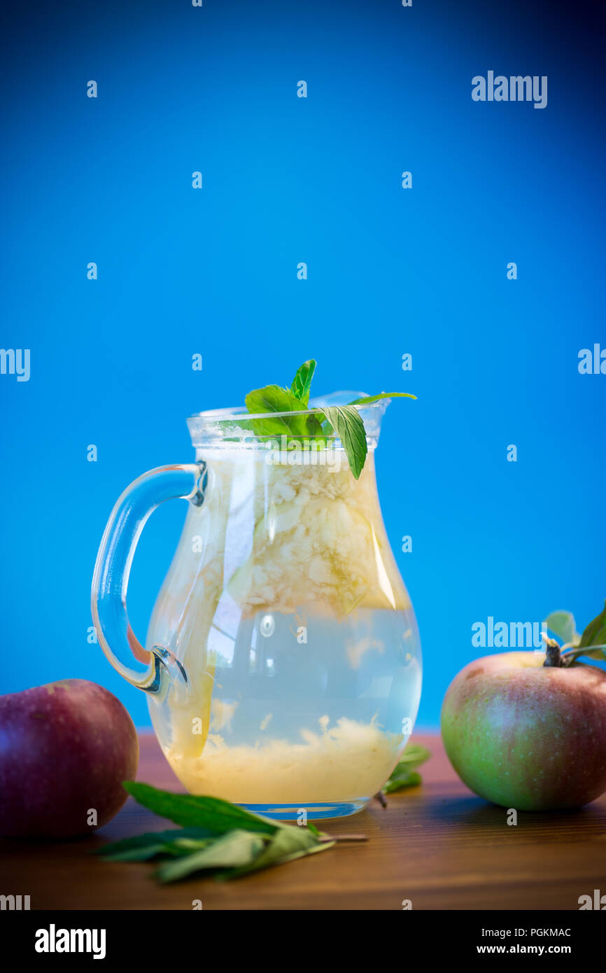Verano frío dulce compota de manzanas frescas con una ramita de menta en un decantador de cristal Foto de stock