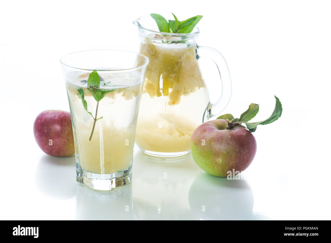 Verano frío dulce compota de manzanas frescas con una ramita de menta en un decantador de cristal Foto de stock