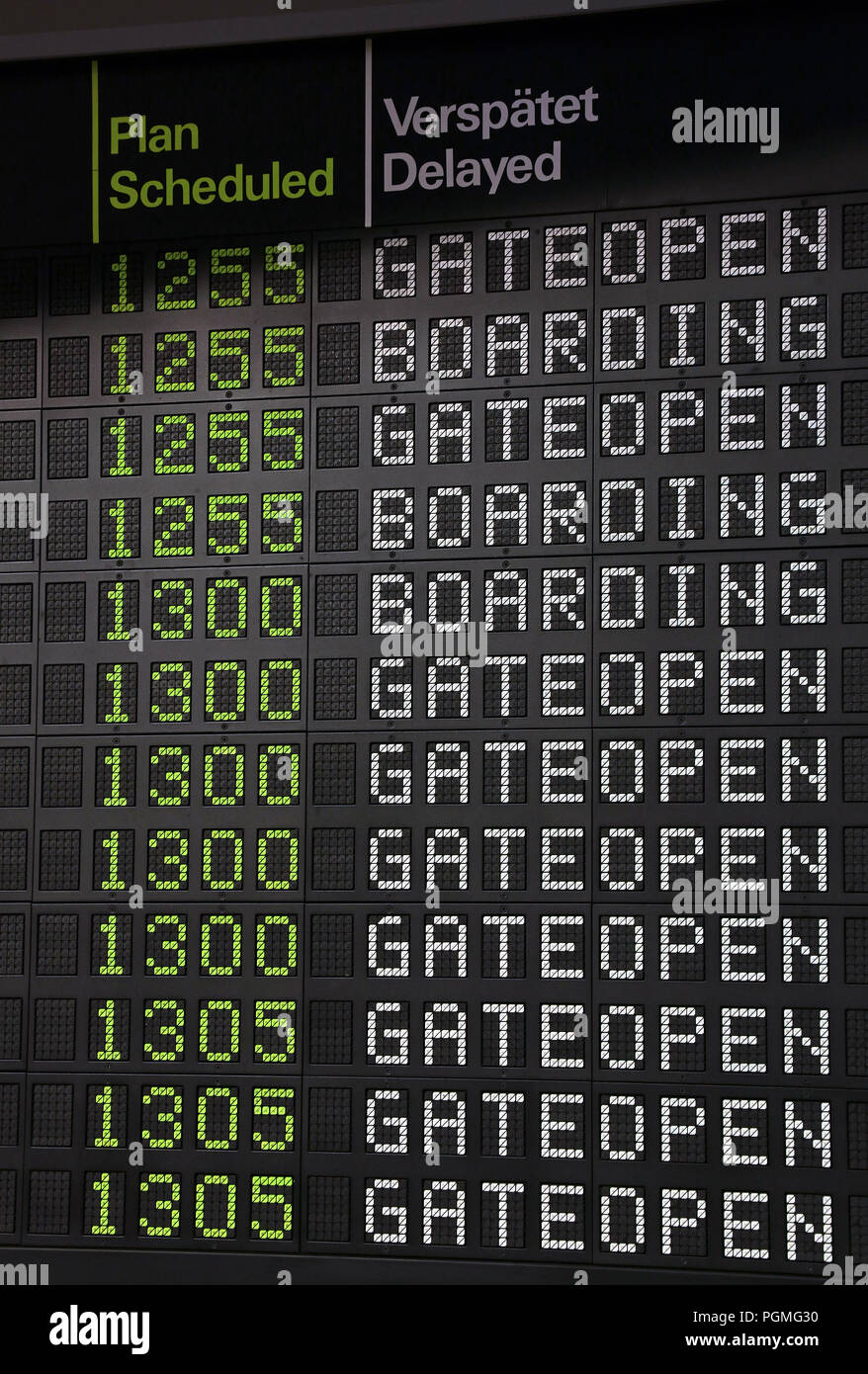 Panel de información de vuelo de recepción en el aeropuerto, con el tiempo, en régimen de internado y los mensajes, cierre de compuerta abierta, vista de ángulo bajo Foto de stock