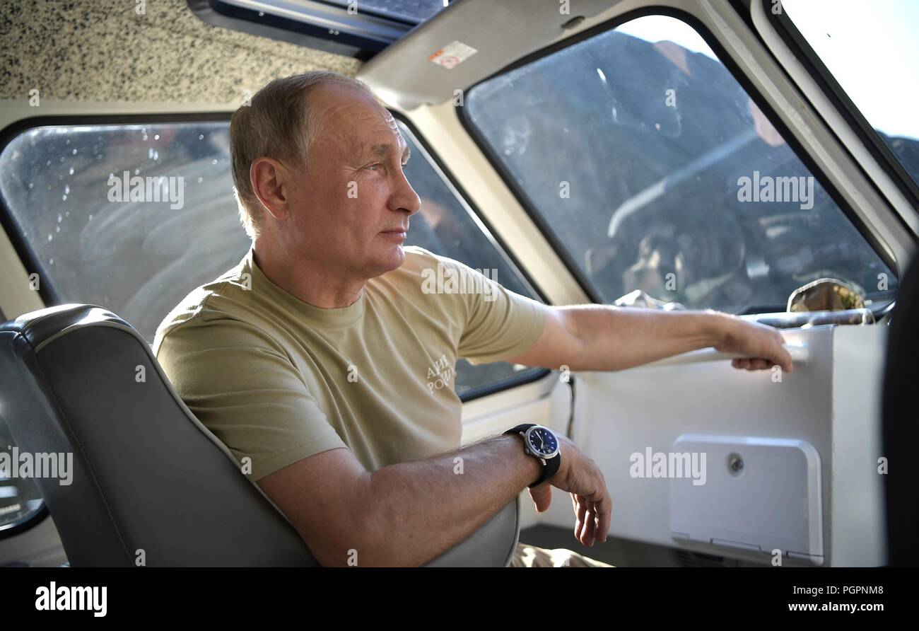 El presidente ruso Vladimir Putin goza del desierto desde un barco durante unas cortas vacaciones en la Reserva Natural Sayano-Shushensky el 27 de agosto de 2018, en la región de Tyva siberiana de Rusia. Foto de stock