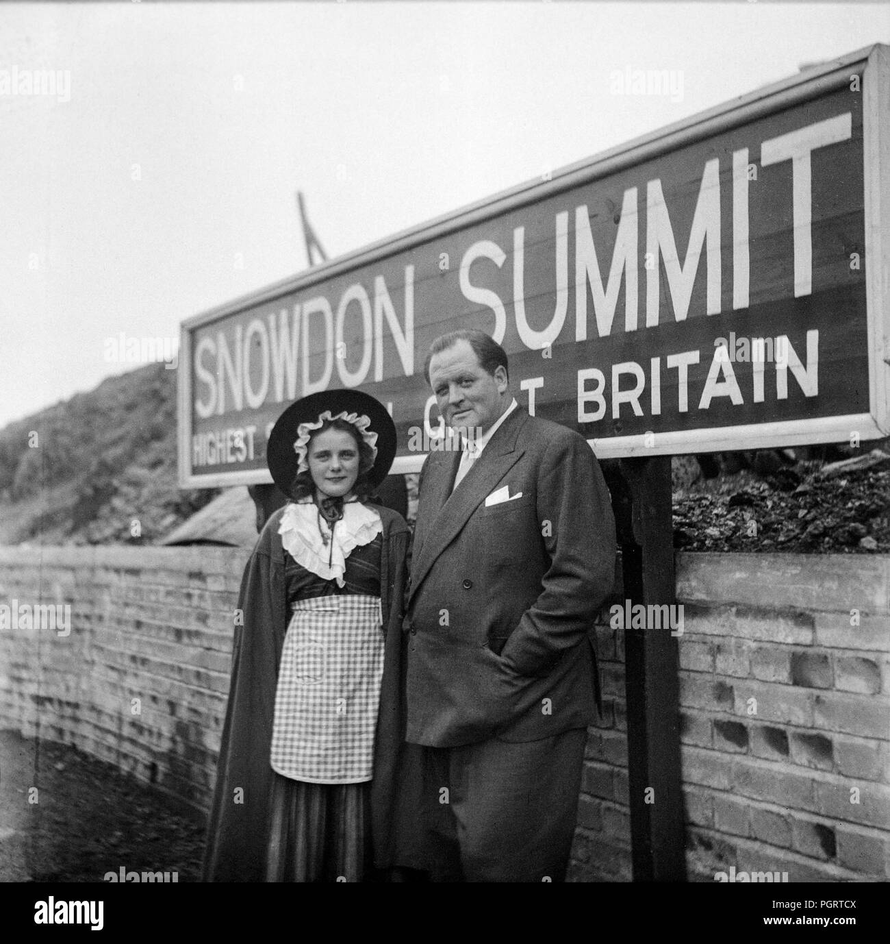 Un hombre y una niña vestida con traje tradicional galés, en la estación de ferrocarril en la cima de Snowdon, la montaña más alta de Gales. foto desde los tempranos 1960s Foto de stock