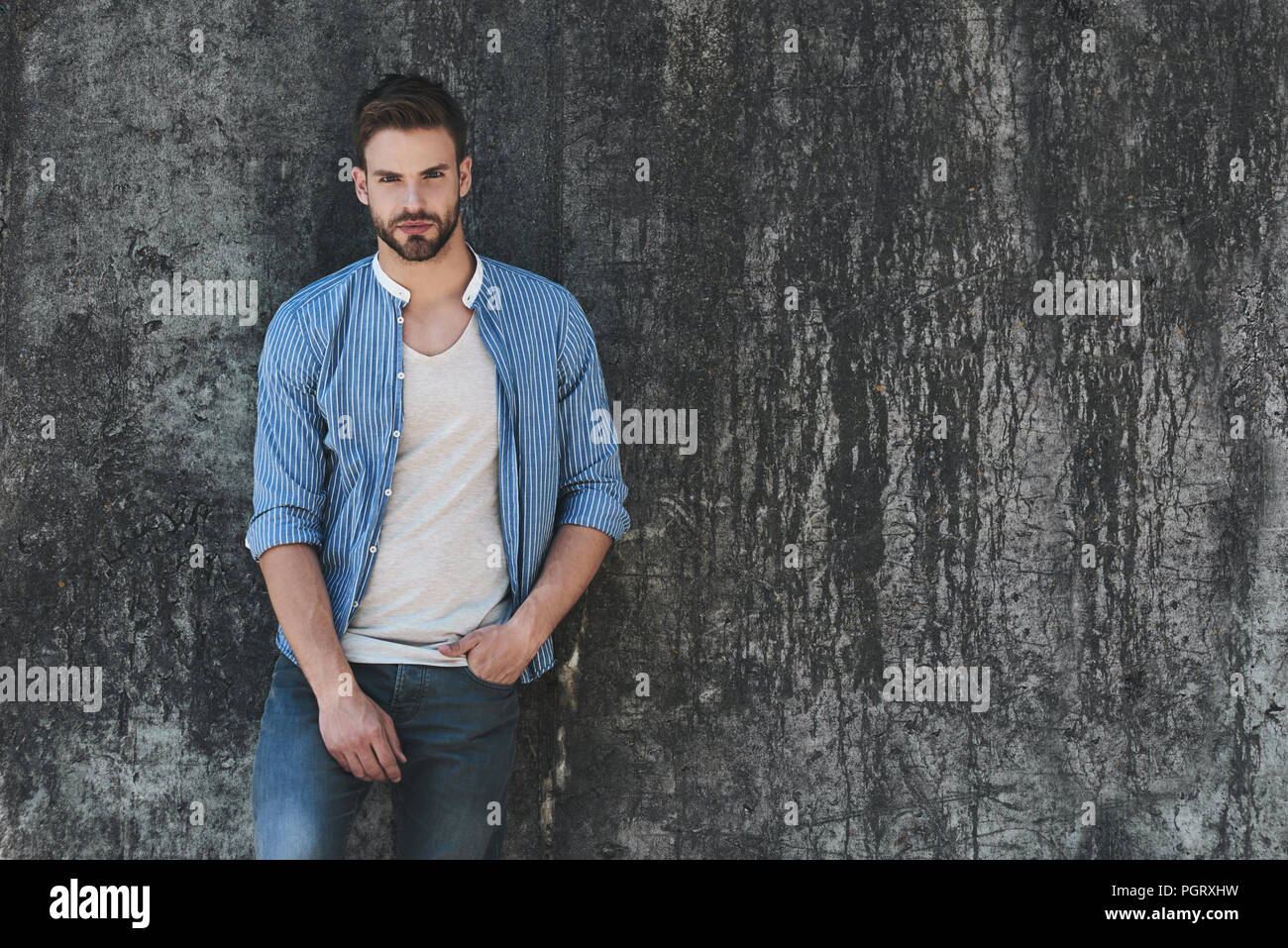 Longitud total retrato de joven apuesto modelo vestida con ropa casual y  pararse en la calle y mirar lejos en el espacio de copia para su publicidad  Fotografía de stock - Alamy