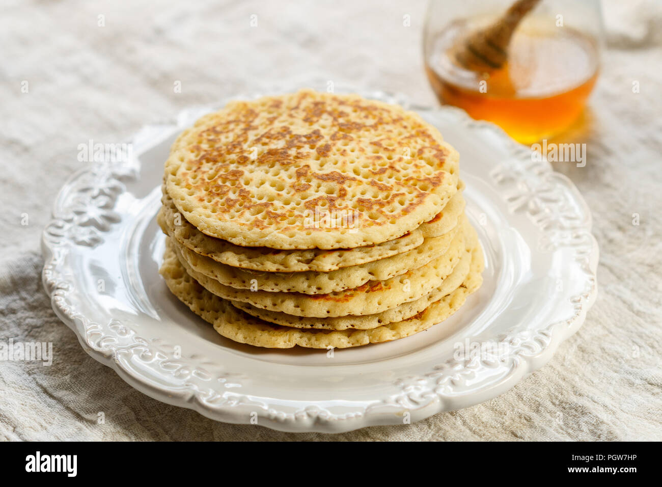 Dulces deliciosos panqueques americanos con miel en una placa blanca. Desayuno gourmet. Enfoque selectivo Foto de stock