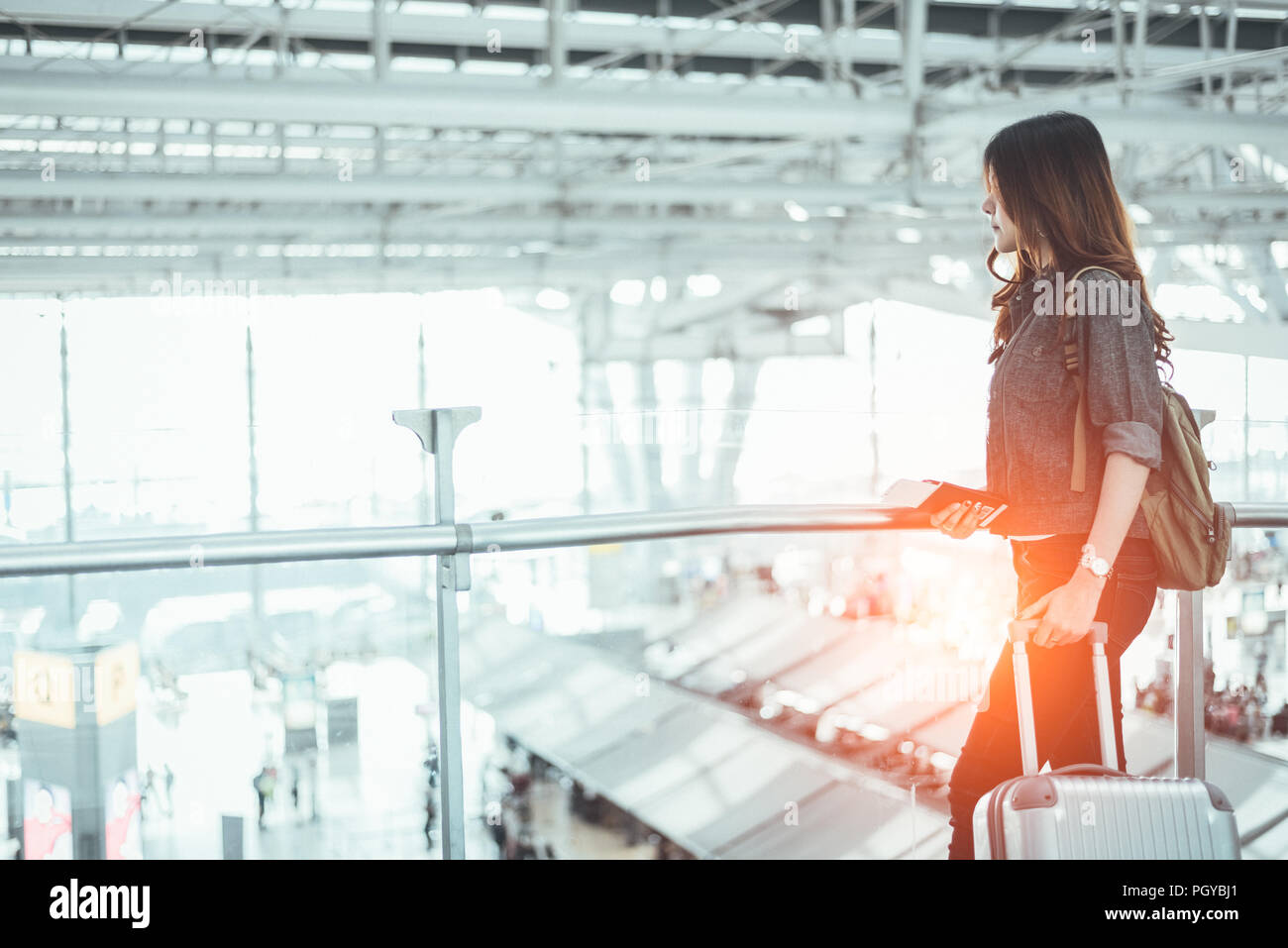 Mujer de belleza esperando para despegar el vuelo en el aeropuerto. Mujer  asiática con maleta trolley. Las personas y los estilos de vida concepto.  Transporte y Viajes theme Fotografía de stock -