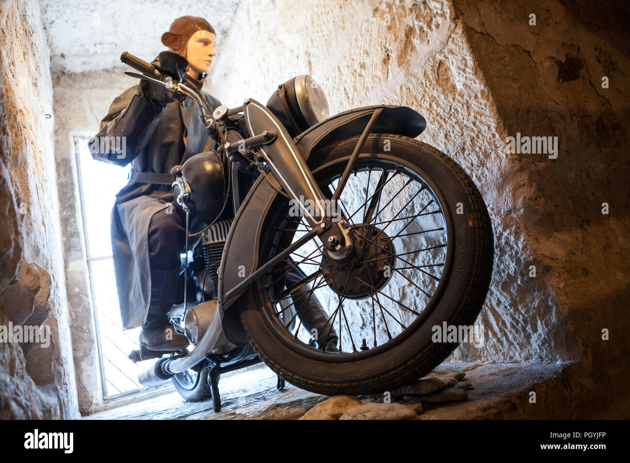 KURESSAARE, ESTONIA - MAR, circa 2018: Antigua motocicleta con estatua de motociclistas como conductor. Joya está en Saaremaa en Kuressaare museo castillo. Wo Foto de stock