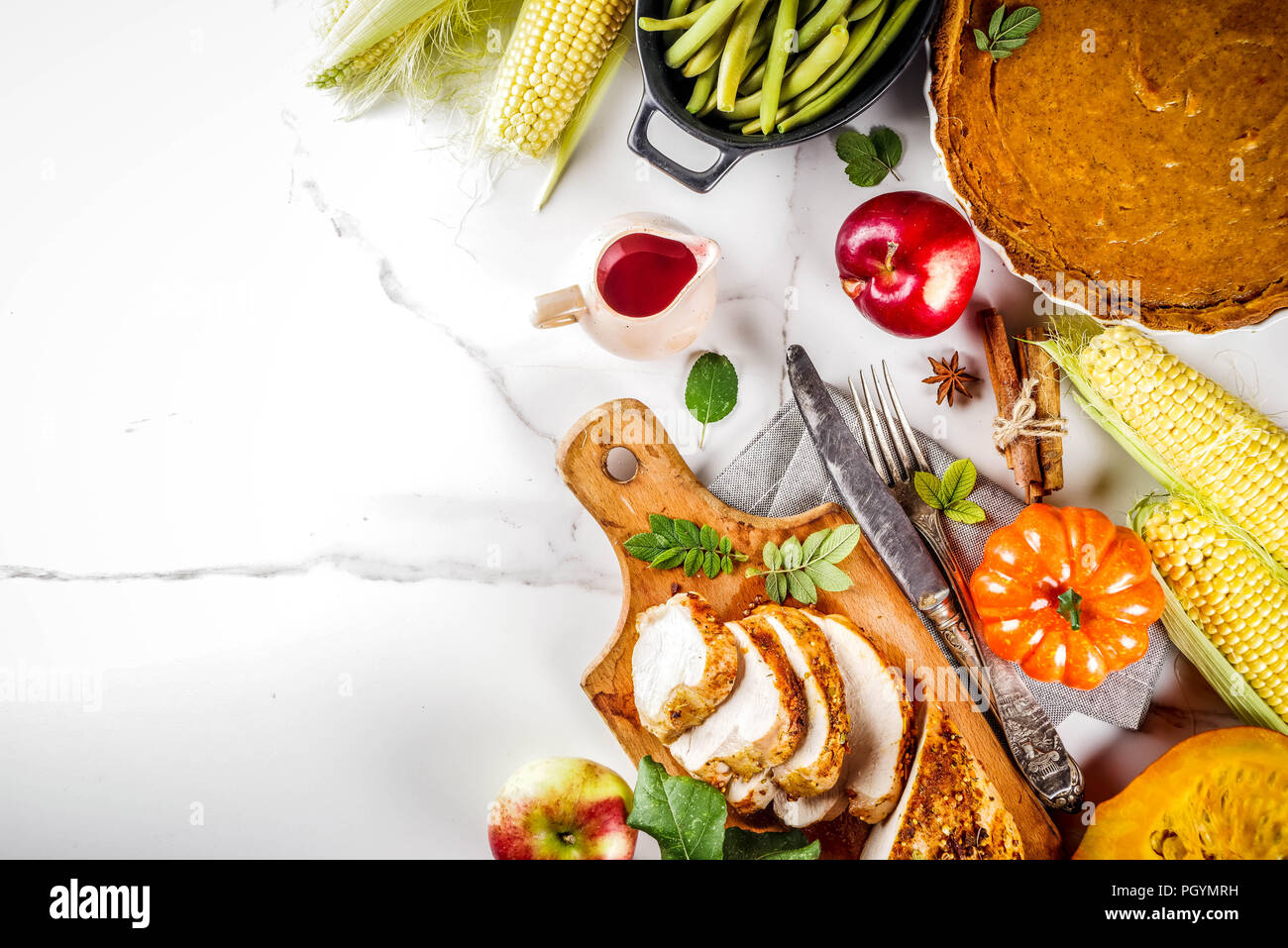 Vacaciones de Acción de Gracias el cuadro con la tradicional comida festiva  - Turquía, pastel de calabaza, calabazas, judías verdes, salsa de  arándanos, maíz, manzanas de otoño, mar blanco Fotografía de stock -