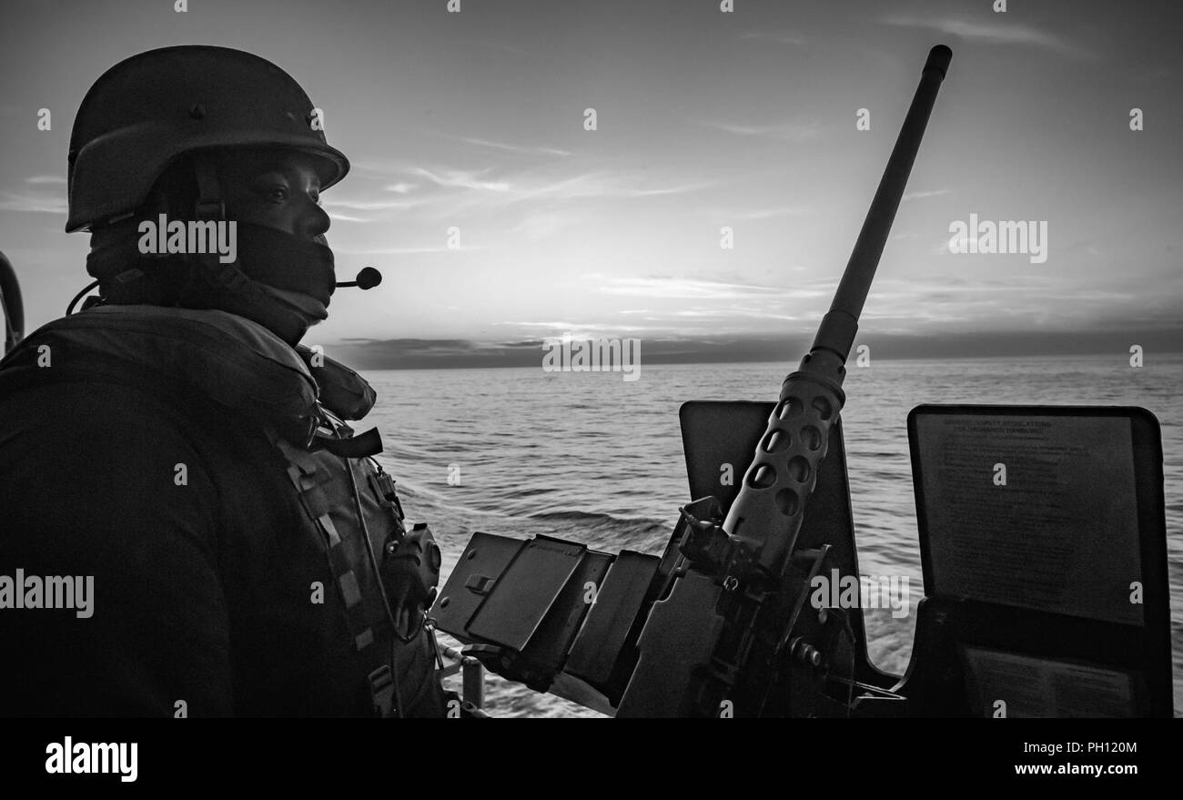Estrecho de Gibraltar (Junio 14, 2018) especialista en logística de 3ª clase Markel Thomas realiza la supervisión mientras vigilaban un .ametralladora calibre 50, a bordo de la clase Arleigh Burke de misiles guiados destructor USS Jason Dunham (DDG 109) durante un estrecho tránsito. Jason Dunham está realizando operaciones navales en los EE.UU. 6ª Flota de la zona de operaciones en apoyo de los intereses de seguridad nacional de EE.UU. en Europa. Foto de stock