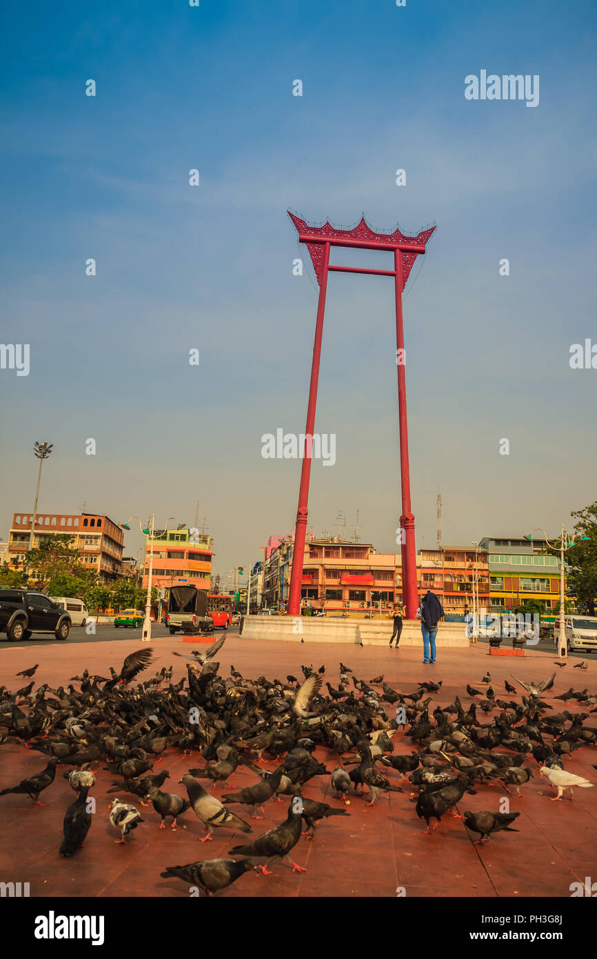 Columpio gigante roja o Sao Ching Cha con la multitud de palomas, una de las más famosas atracciones turísticas y monumentos en Bangkok, Tailandia. Foto de stock