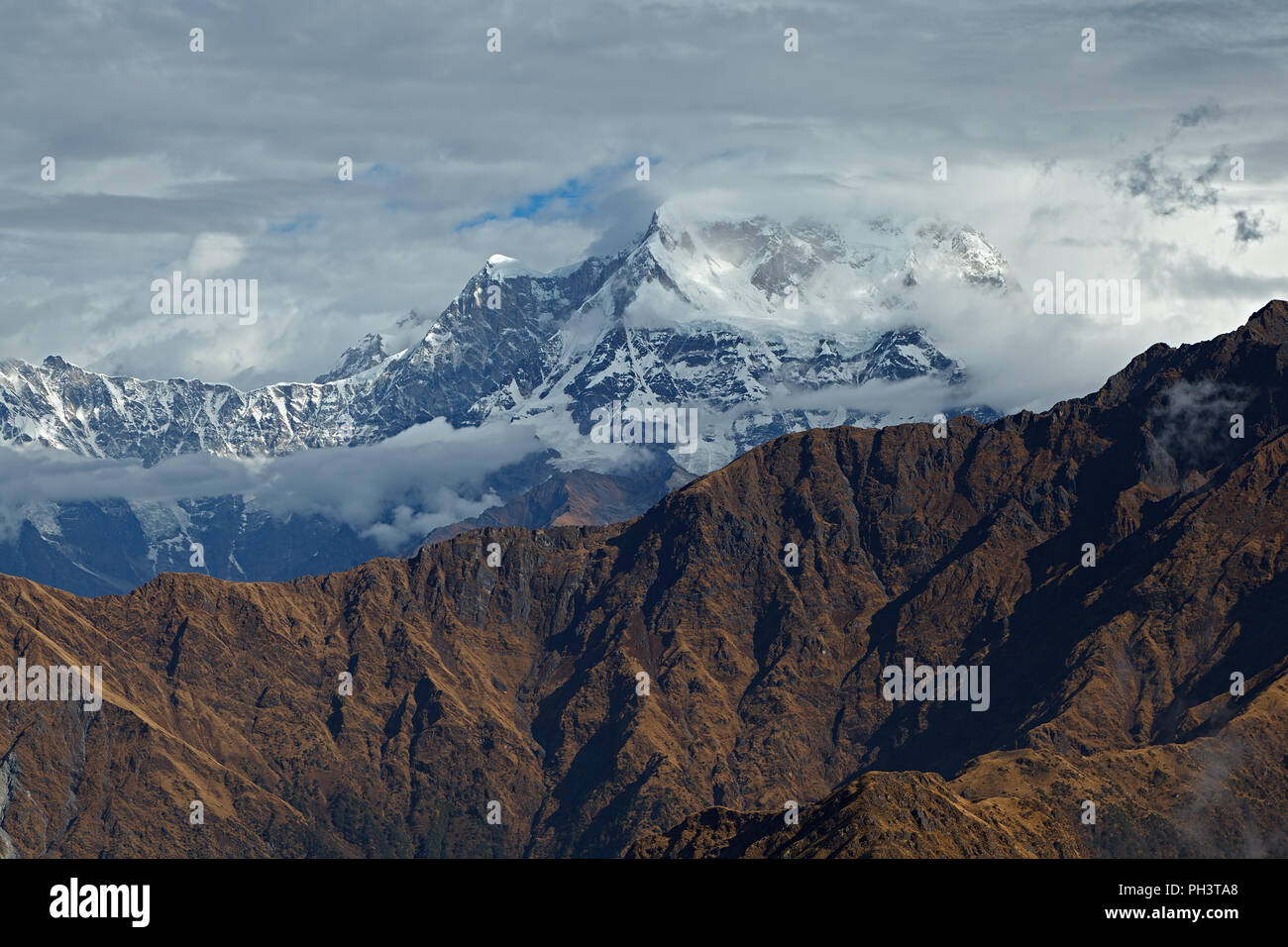 El pico de la montaña de Chaukamba entre nubes marrón con cresta de la montaña en primer plano, el Himalaya, Uttarakhand, India. Vista desde el Monte Chandrashila Foto de stock