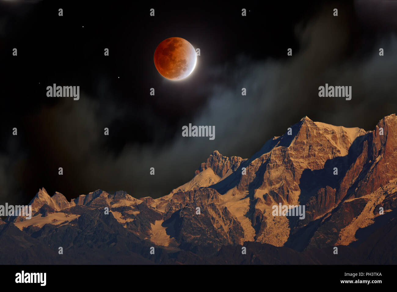 Un eclipse total de Luna con la Luna roja en la noche en el Misty nubes sobre montañas del Himalaya Foto de stock