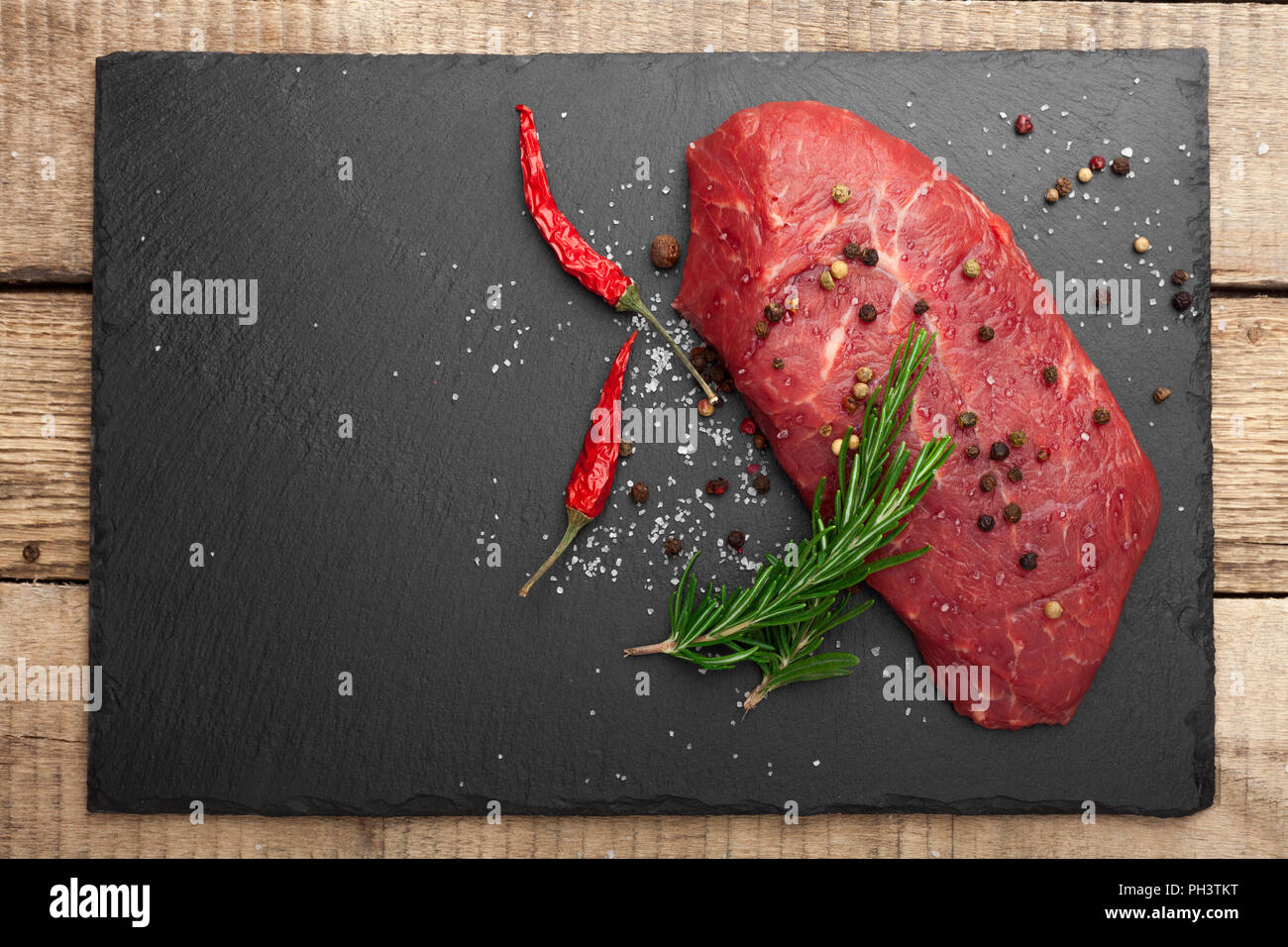 Carne fresca cruda.Chuletón.Filetes de carne fondo negro pizarra Stock  Photo