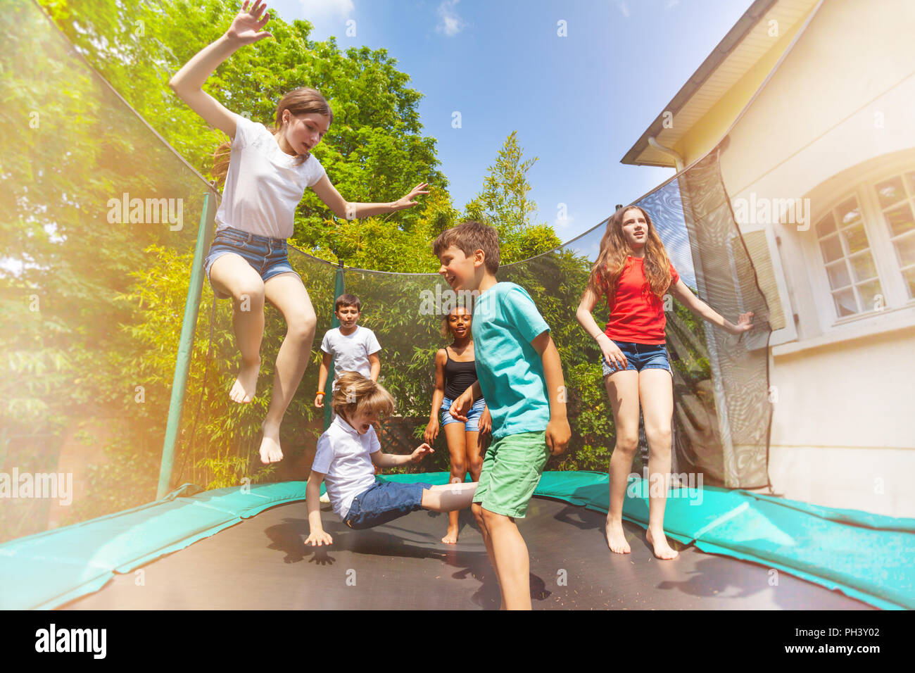 Los niños felices saltando sobre la cama elástica de exterior Fotografía de  stock - Alamy