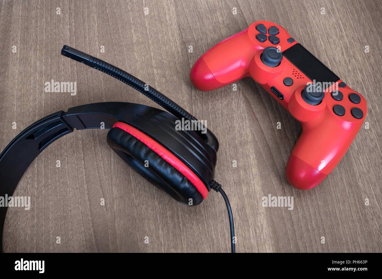 Auriculares y controlador de juegos de vídeo de color rojo. Foto de stock