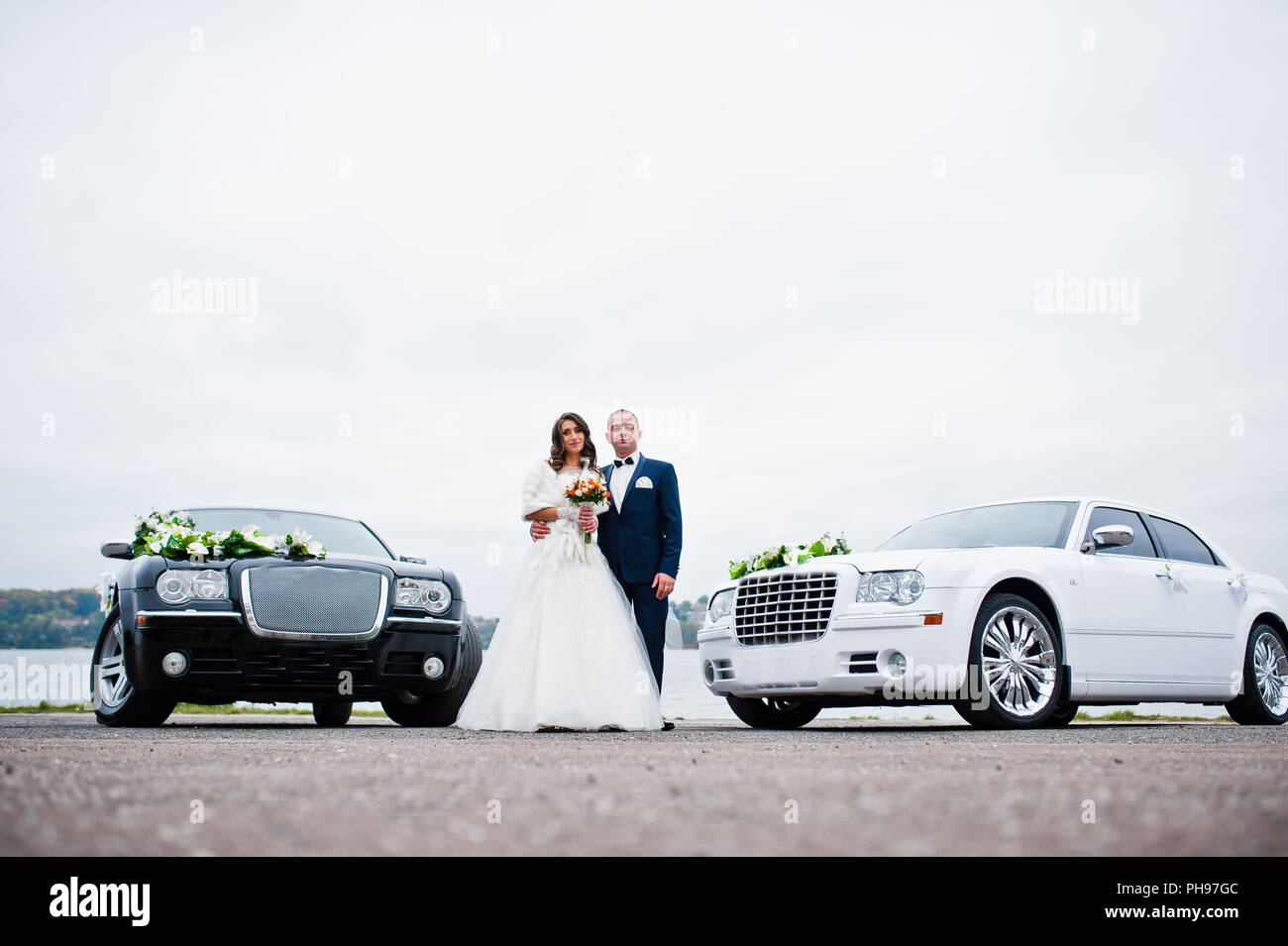 Pareja de novios antecedentes dos coches de boda en blanco y negro Foto de stock
