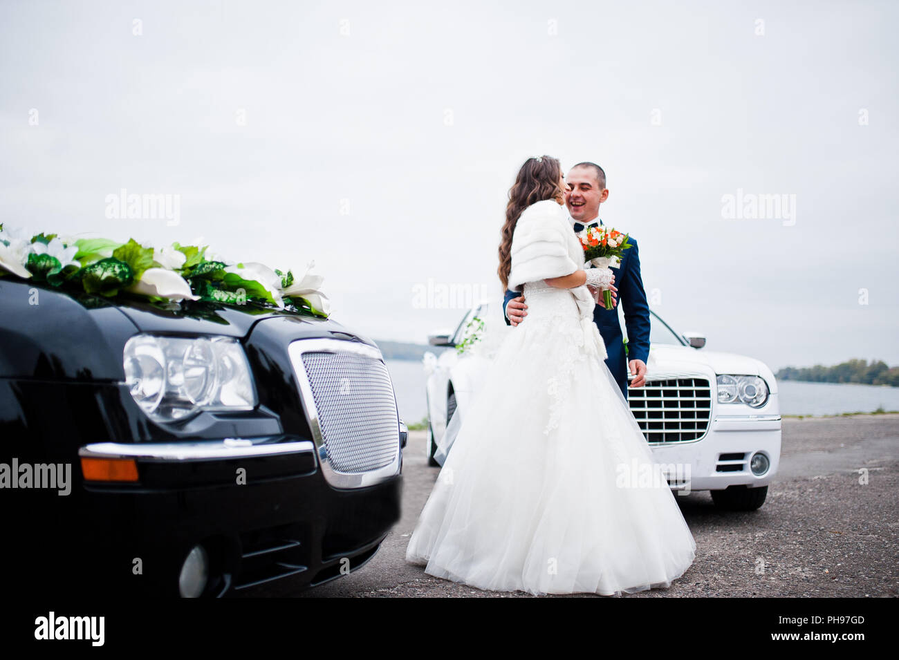 Pareja de novios antecedentes dos coches de boda en blanco y negro Foto de stock