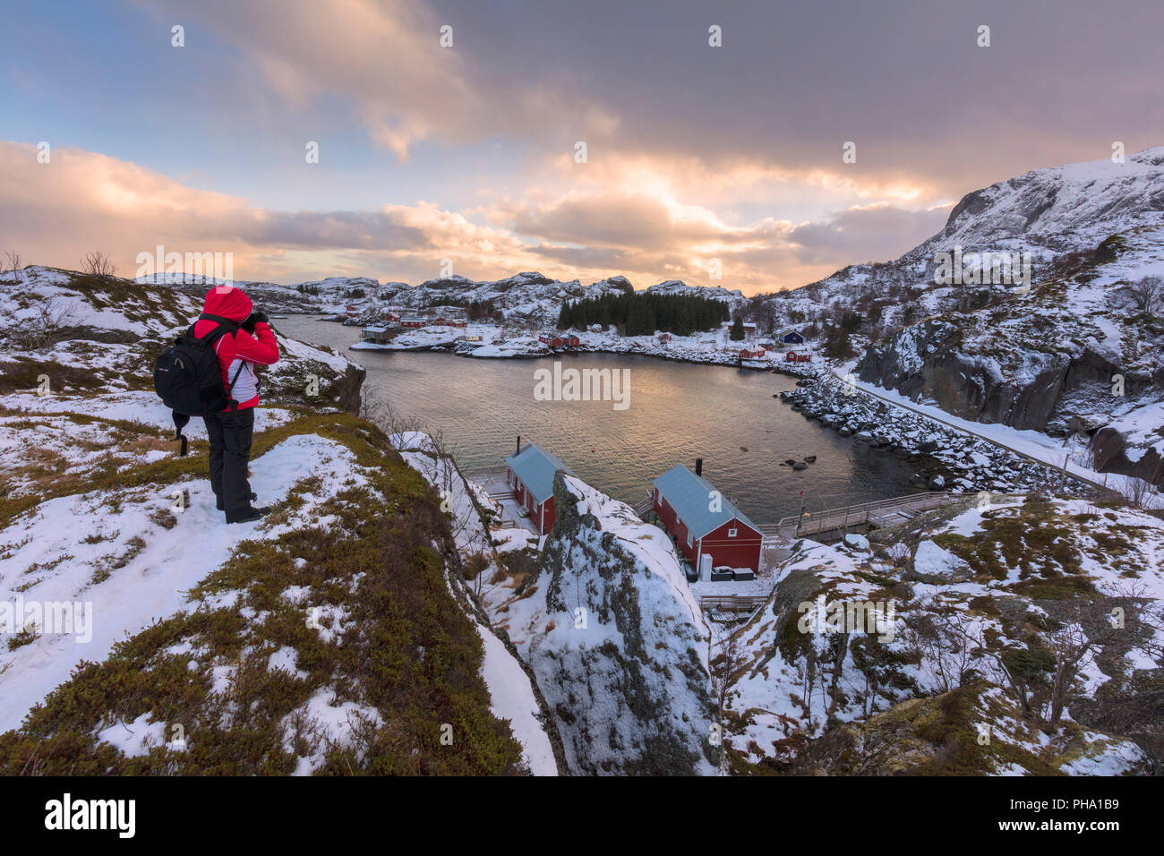 Fotógrafo en pico rocoso, Nusfjord, Islas Lofoten, Nordland, Noruega, Europa Foto de stock