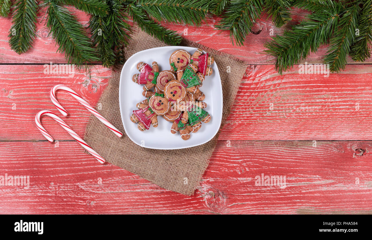 Rústicos tablones de madera roja con galletas de Navidad y bastones de caramelo Foto de stock