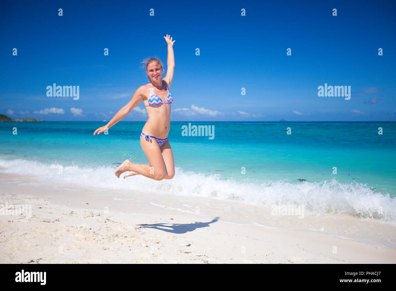 Feliz saltando chica en bikini en la playa Foto de stock
