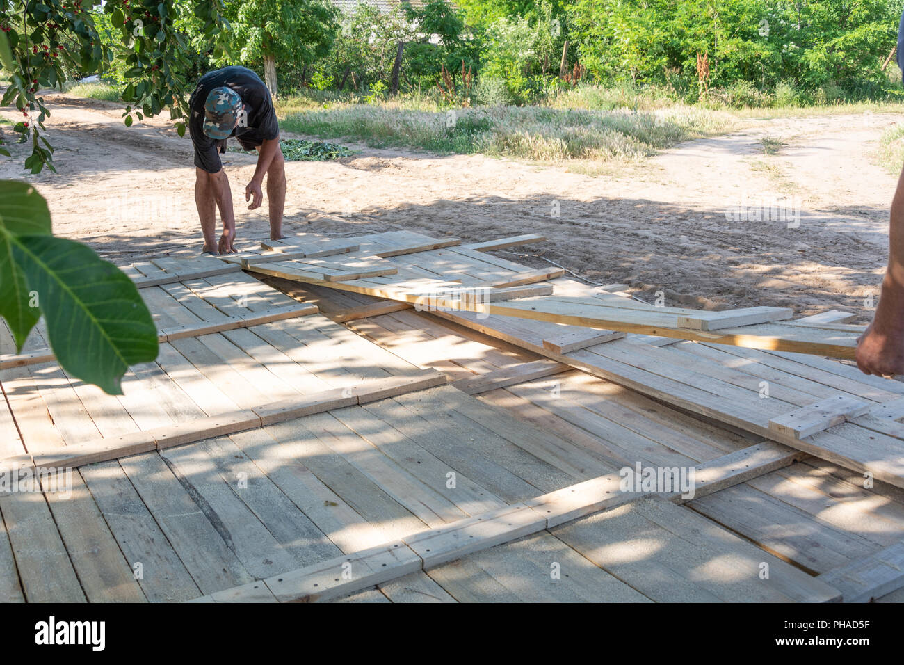 El hombre la construcción de una valla de madera. Los trabajadores levantan placas de madera para el encofrado de cerco. Formworks madera para hormigón en obra. Foto de stock