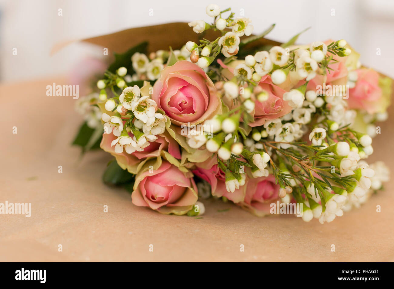 Precioso ramo de rosas rosas y margaritas en el papel artesanal. Flores.  Presente de cumpleaños. Elegante ramo de flores listo para envolver  Fotografía de stock - Alamy