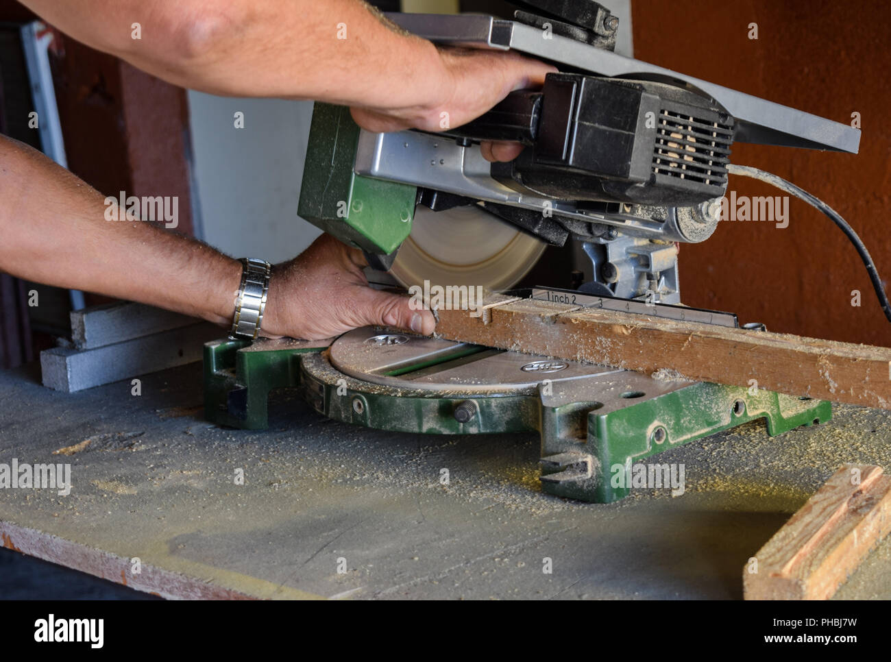 Trabajador feliz cortando madera con serrucho en el sitio Fotografía de  stock - Alamy