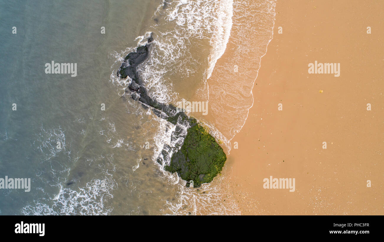 Una foto aérea de un yin yang formación rocosa en el mar, mostrando el color de la arena y el agua Foto de stock