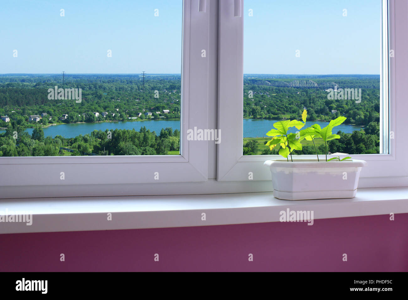 Maceta de flores en el alféizar de la ventana y ver a las casas de campo Foto de stock