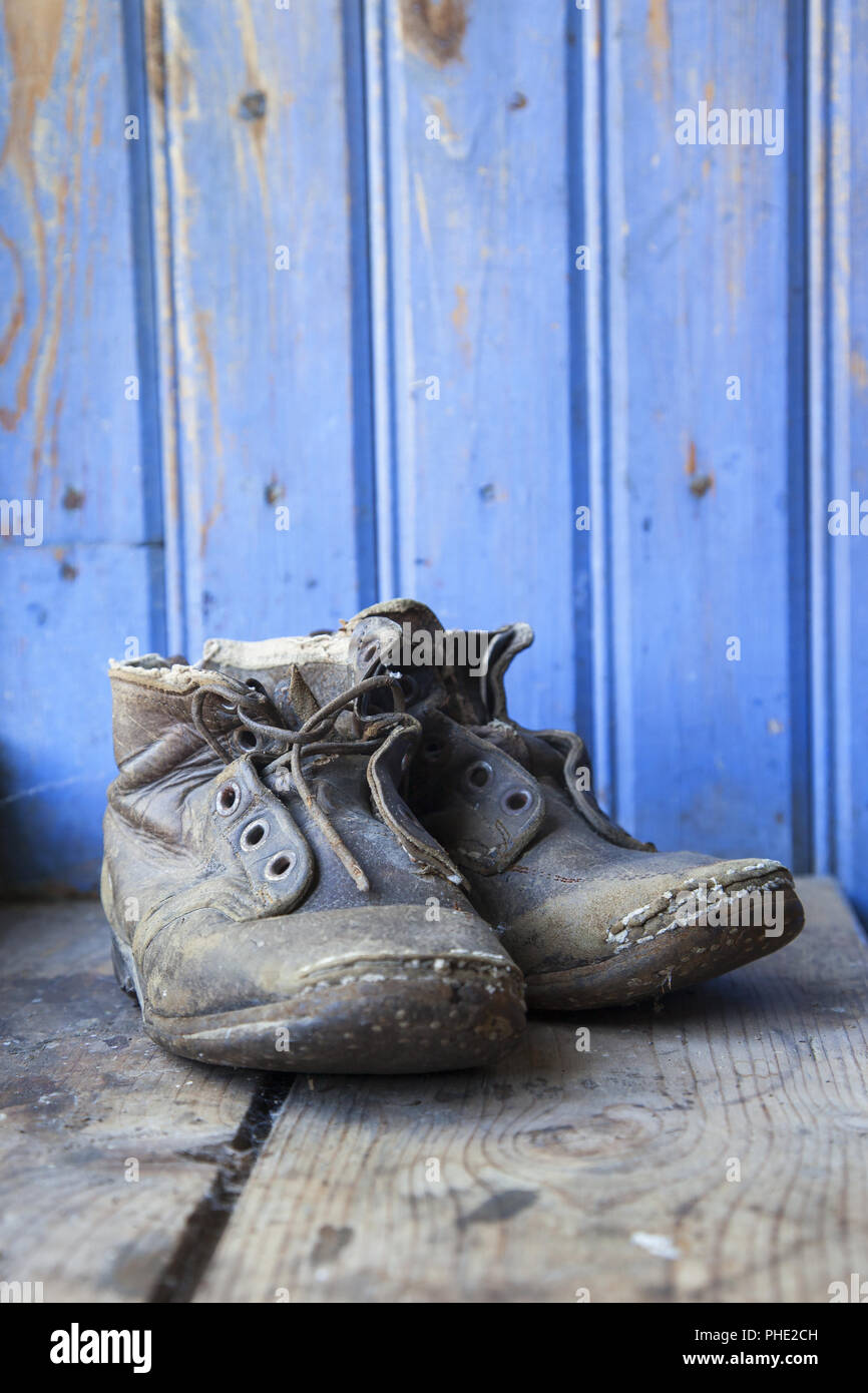 Viejos zapatos desgastados sobre un piso de madera Fotografía de stock -  Alamy