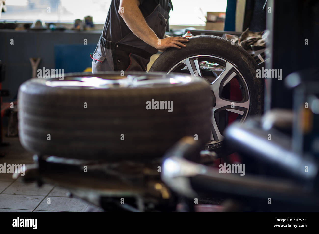 El equilibrado de las ruedas o la reparación y cambio de neumáticos de  coche en el garaje o el taller de auto servicio por mecanico Fotografía de  stock - Alamy