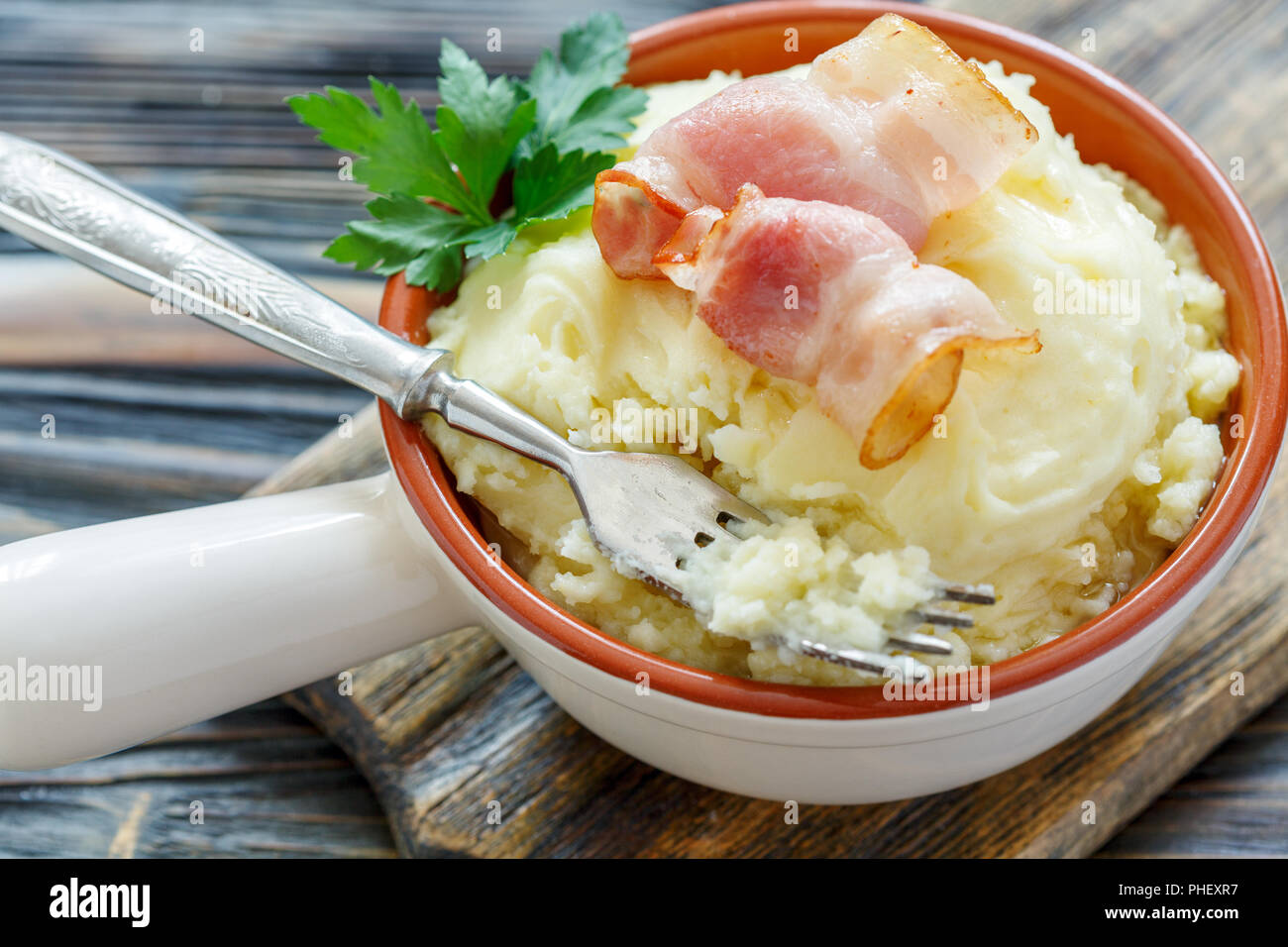 En un tazón de horquilla con puré de papas y tocino. Foto de stock