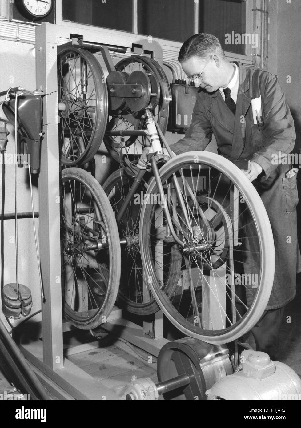 Fábrica en la década de 1950. Un trabajador de la empresa de motocicletas y bicicletas Monark en Suecia.Las bicicletas están siendo probadas y de esta máquina llamada el agitador, la bicicleta se ejecuta a 1000 km de la ejecución de la prueba. Suecia 1958 Foto de stock