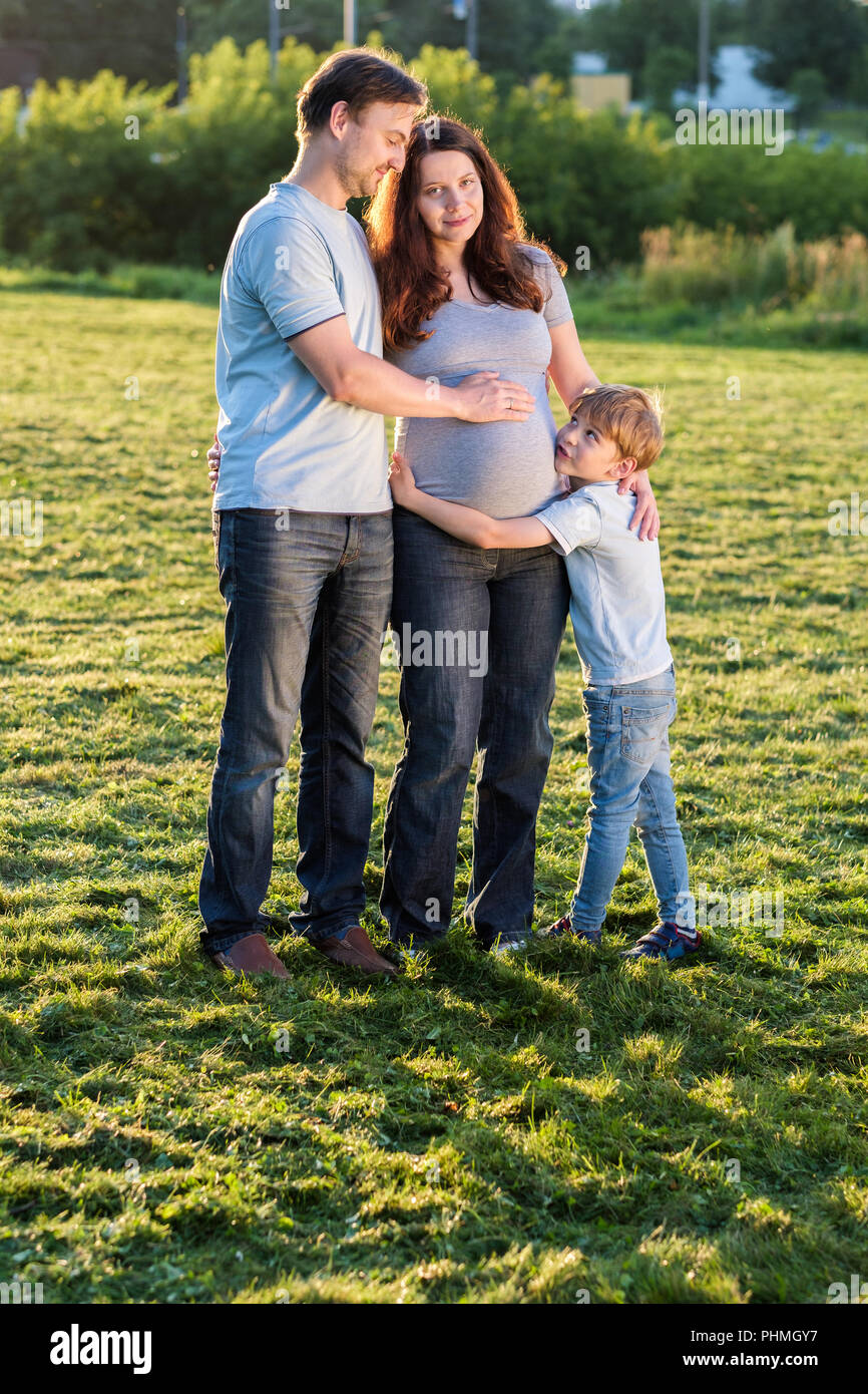 Feliz familia embarazada de tres esperando nuevo bebé Fotografía de stock -  Alamy