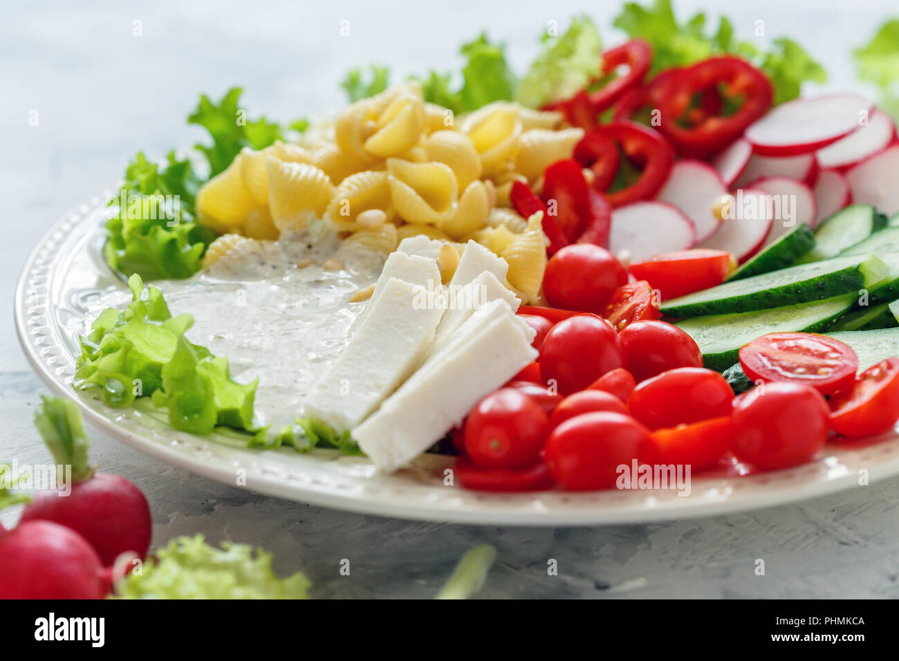 Ensalada de verduras con pasta y queso fresco. Foto de stock