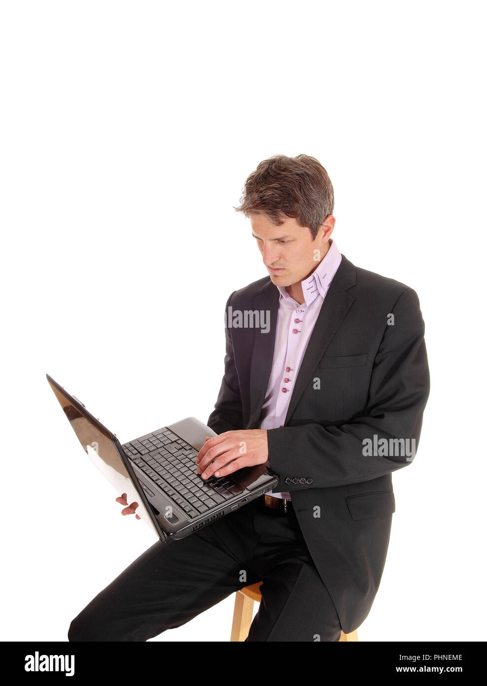 Hombre de negocios sentado y trabajar en su portátil. Foto de stock