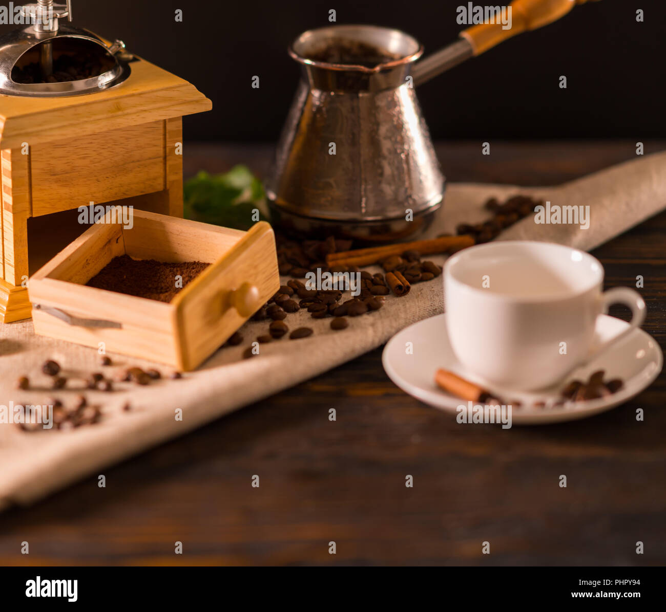 Abra el cajón de un molino de café con café recién molido en un paño blanco  junto a una taza y una cafetera en una rústica cocina Fotografía de stock -  Alamy