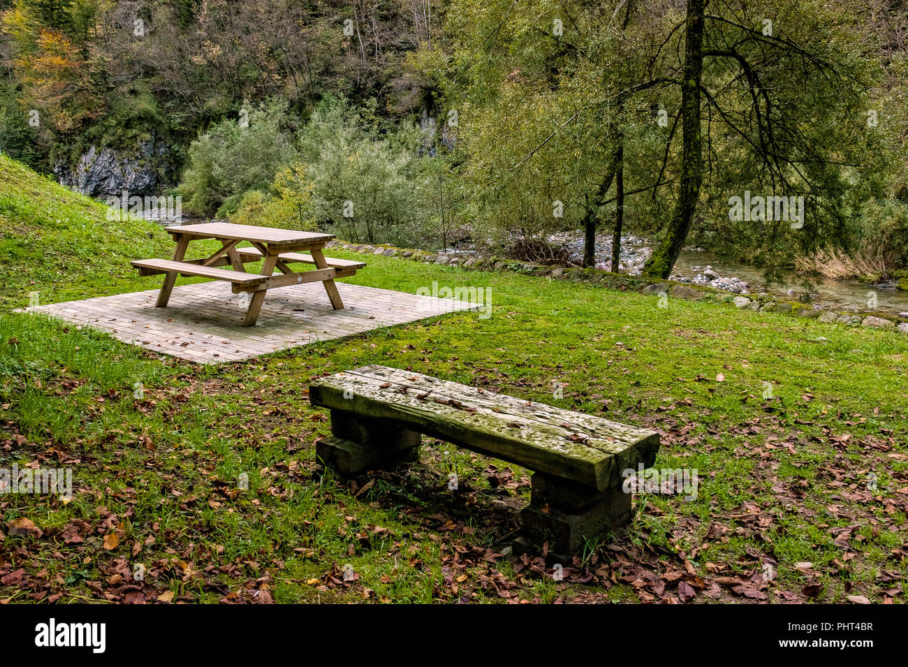 Bancos y mesa de madera para el picnic en la pradera de montaña en otoño Foto de stock