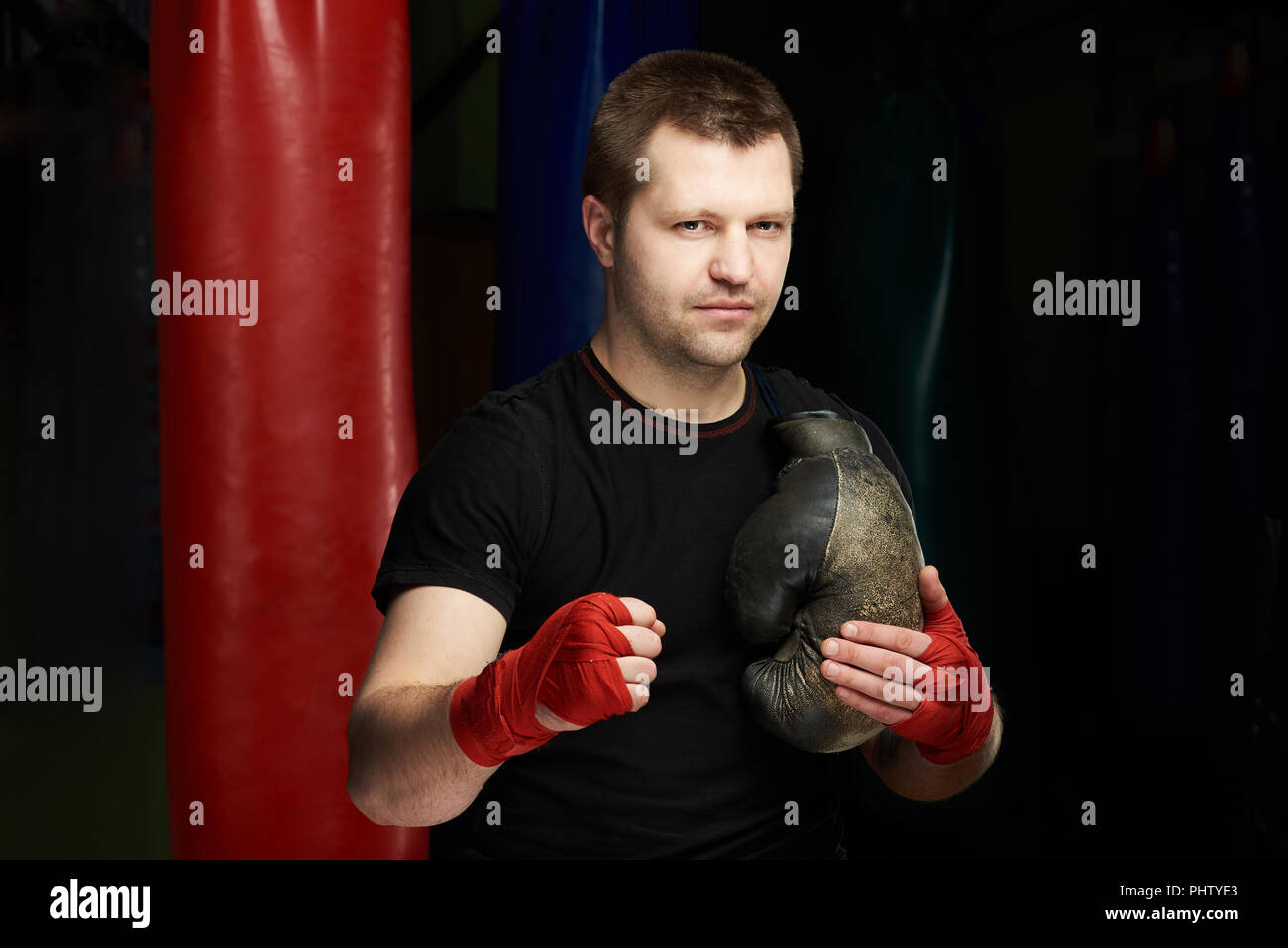 Retrato del hombre caucásico de boxeo con guantes en el gimnasio fondo sucio Foto de stock